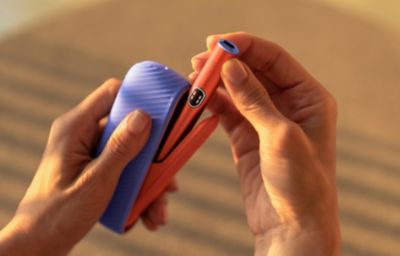 Person nimmt IQOS Tabakerhitzer aus dem Kit heraus.