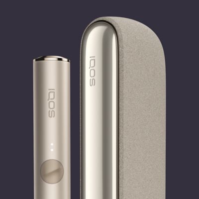 IQOS ILUMA Tabakerhitzer in der Farbe Pebble Beige abgebildet vor einem dunklen Hintergrund.