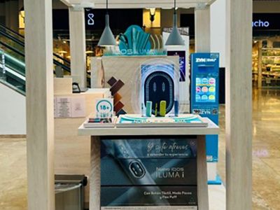 Dispositivos IQOS ILUMA ubicados dentro de exhibidor cilíndrico azul.