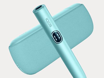 Держатель IQOS ILUMA i PRIME цвета Лазурный бриз перед зарядным устройством на сером фоне