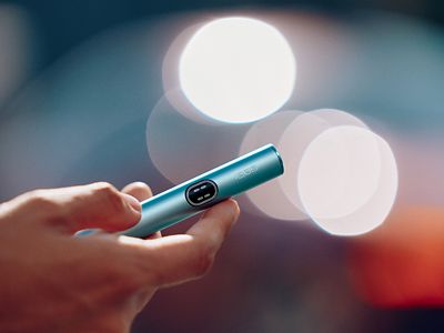  Persona sosteniendo una pieza de calentamiento de un IQOS ILUMA i color Breeze Blue en su mano