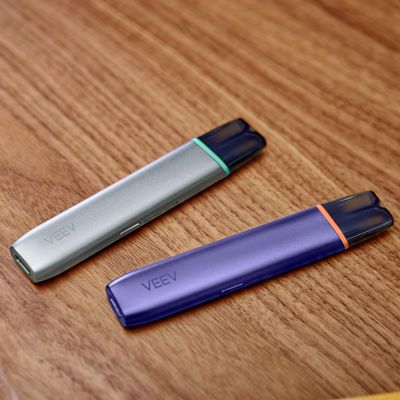 Zwei VEEV ONE Devices liegen auf einer Holzoberfläche