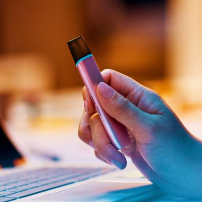 Eine Hand hält ein VEEV ONE Device in Lucious Pink