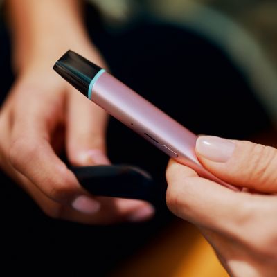 Jemand hält ein VEEV ONE Device in Lucious Pink mit eingesetztem Pod in der Hand