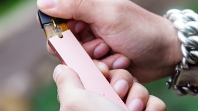 Jemand entnimmt ein Pod aus einem E-Vape