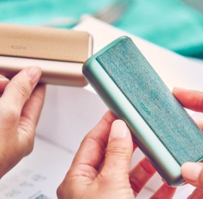 Zwei Personen halten zwei IQOS ILUMA Geräte in der Hand