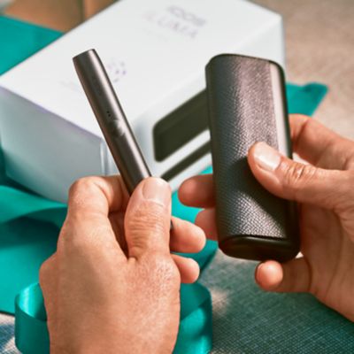 Jemand packt ein IQOS ILUMA Kit aus