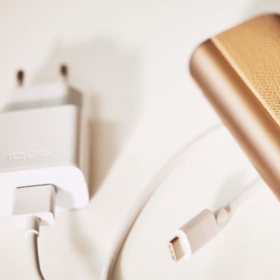 Ein IQOS ILUMA PRIME Pocketcharger neben einem USB-C-Ladekabel