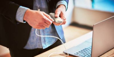 Person with a IQOS holder and a mobile in his hands in the dark