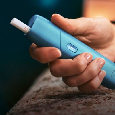 IQOS ORIGINALS ONE in turquoise in einer Hand