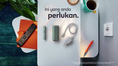 A charging cable being inserted into an IQOS ILUMA PRIME holder.