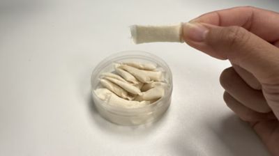 a hand holding a nicotine pouch