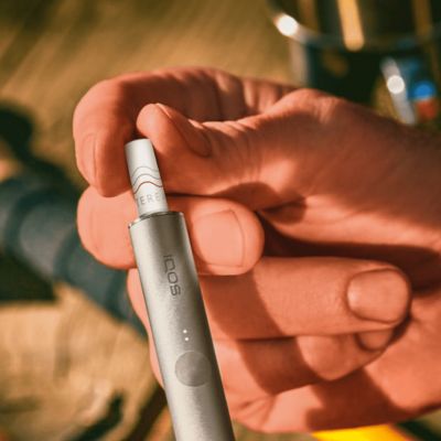 IQOS ILUMA Holder mit TEREA Heatstick in der Hand eines Mannes