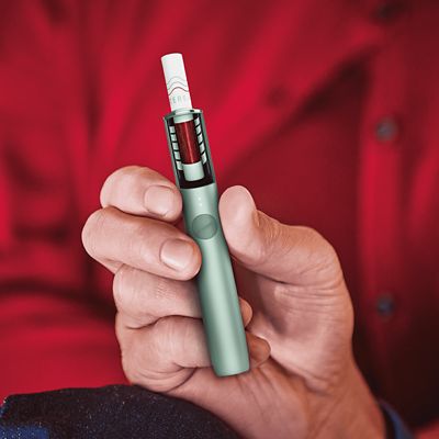 Ein IQOS ILUMA Holder mit TEREA Sticks wird in der Hand gehalten