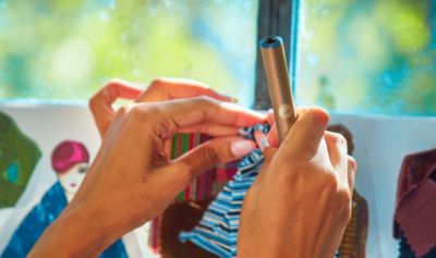 Ruky držiace zariadenie IQOS.