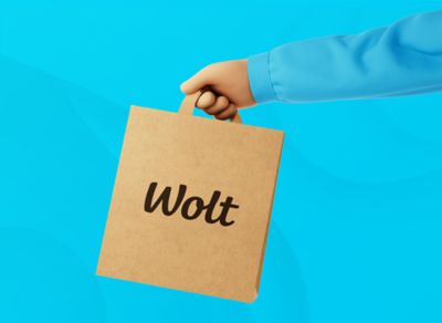 Kreslená ruka držiaca hnedú tašku s nápisom Wolt