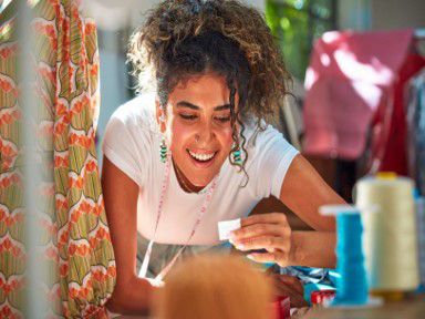 Žena umelkyňa sa smeje s papierikom v ruke