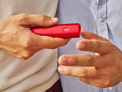 Une personne passe un appareil BONDS by IQOS à son ami.