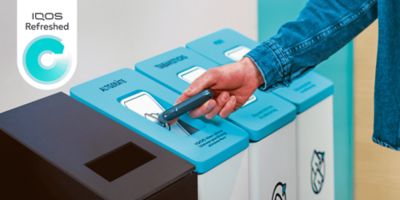 Jemand wirft sein IQOS Device in einen Sammelbehälter