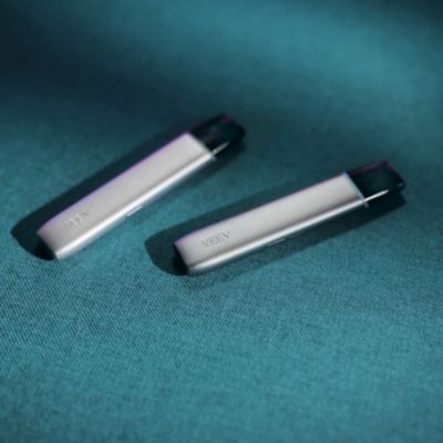 2 ecig VEEV ONE grise posée sur un fond bleu