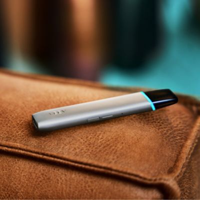 ecig VEEV ONE grise posée sur une surface en cuire