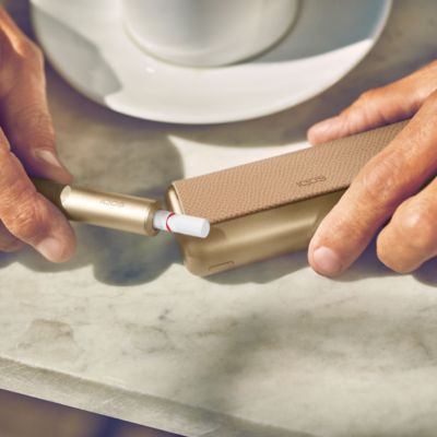 Ein IQOS ILUMA Gerät in den Händen eines Mannes.