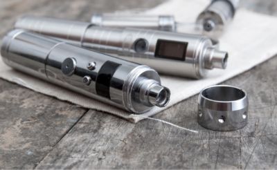 Silberne E-Zigarette, liegend auf Tisch, geöffnet.