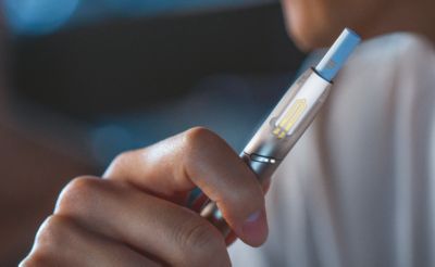 Hand hält einen IQOS DUO Holder , Heizblatt ist sichtbar