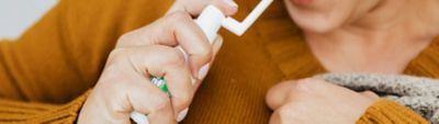 شخص يستخدم بخاخًا فمويًا، يوضح كيفية استخدام بخاخ النيكوتين عن طريق الفم