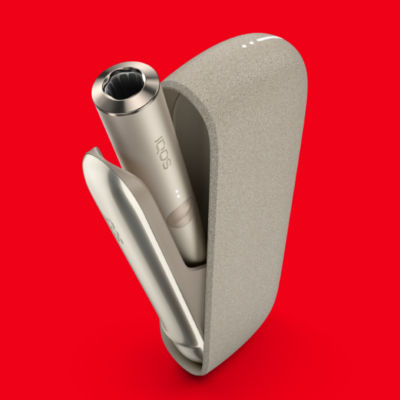 Béžové zařízení IQOS ILUMA na červeném pozadí