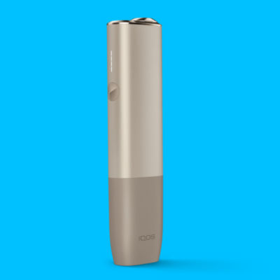 Béžové zařízení IQOS ILUMA ONE na modrém pozadí