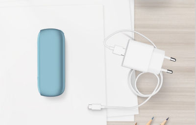 Türkisfarbener IQOS ORIGINALS DUO Pocket Charger neben dem Ladegerät.